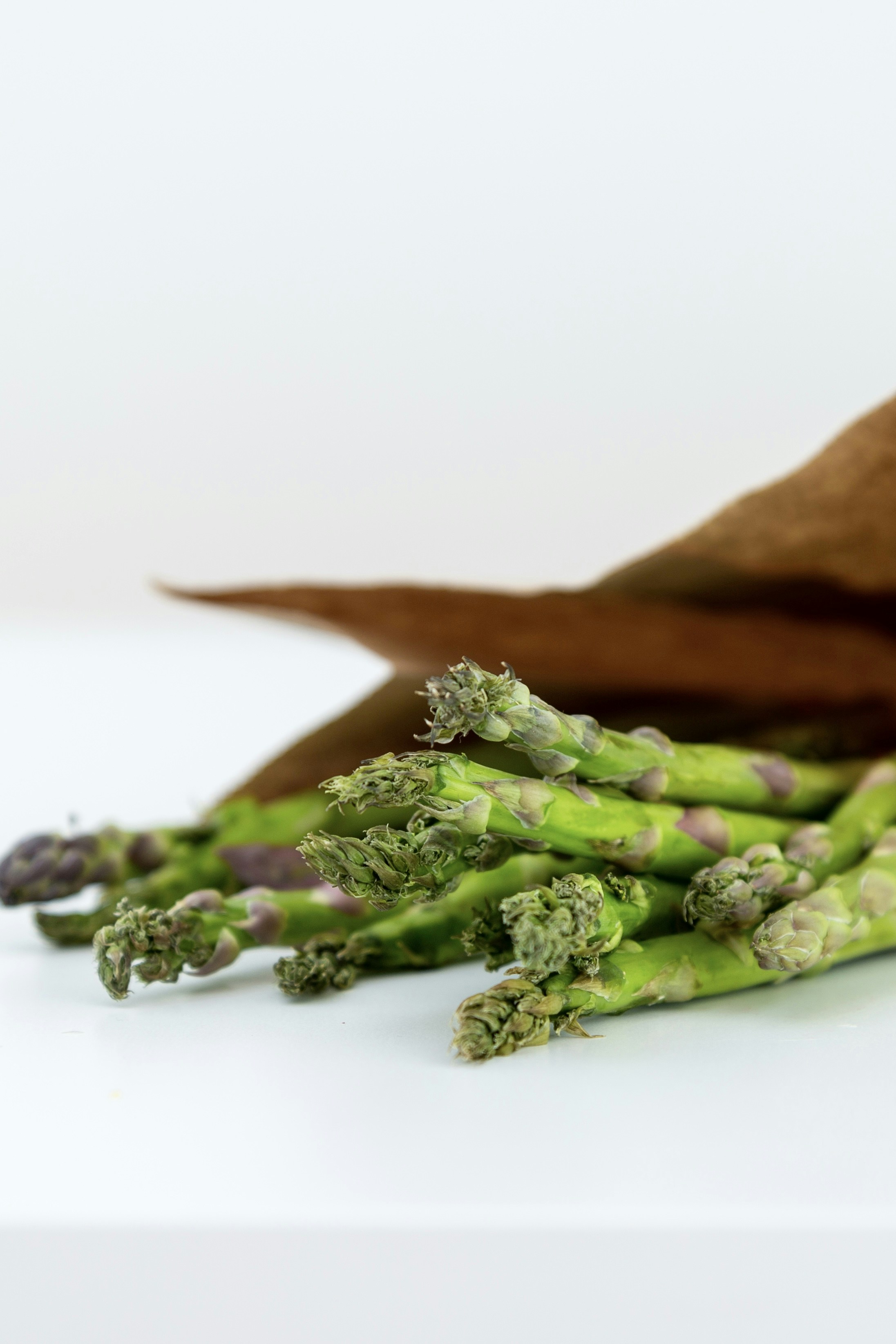 a bunch of green asparagus on a white surface