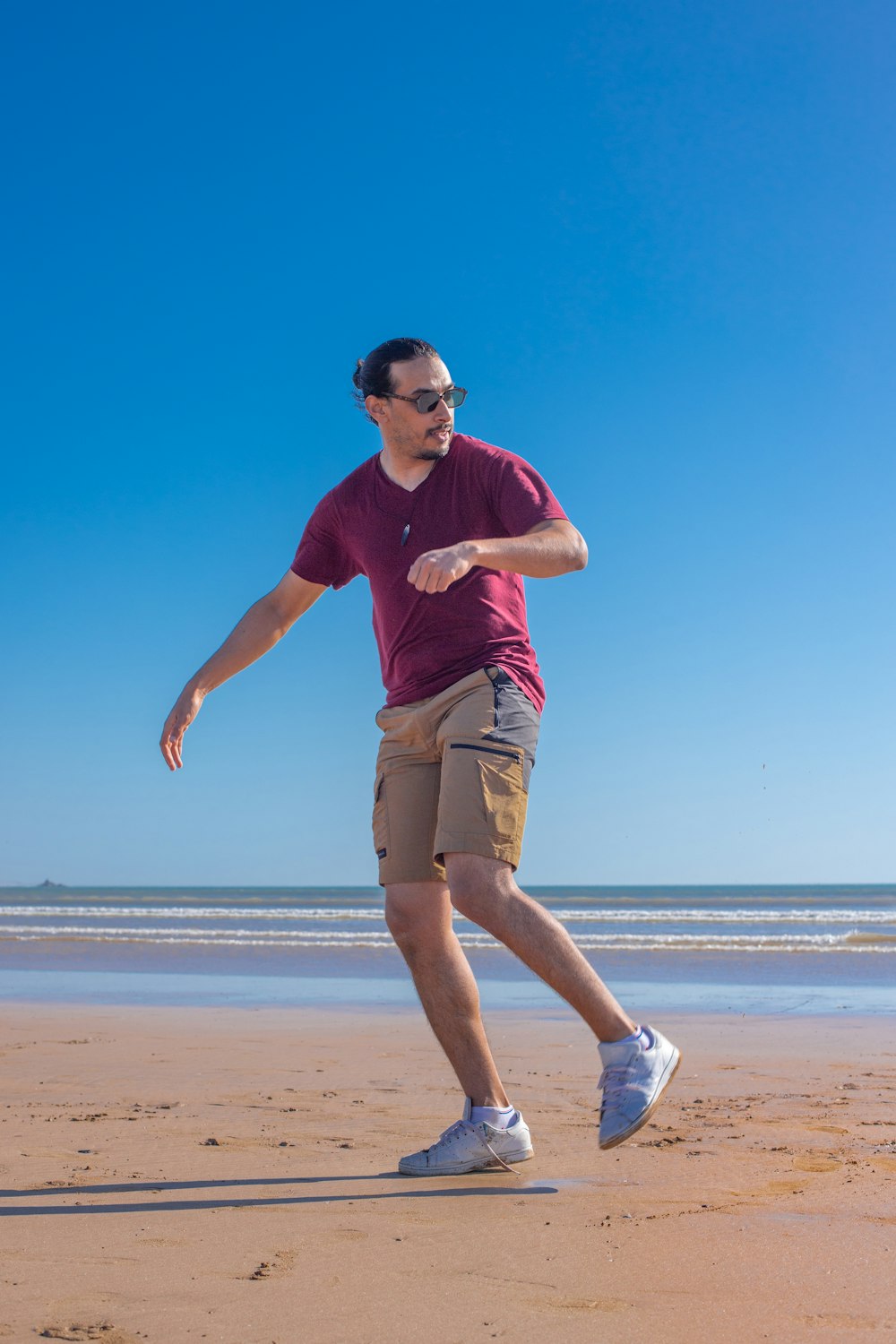 a man on a beach throwing a frisbee