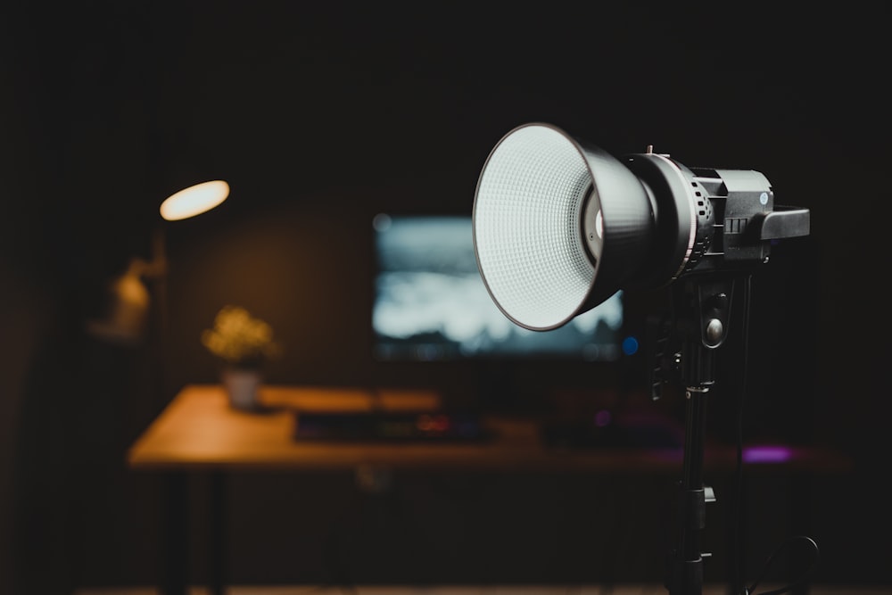 a camera with a light on a tripod in a dark room