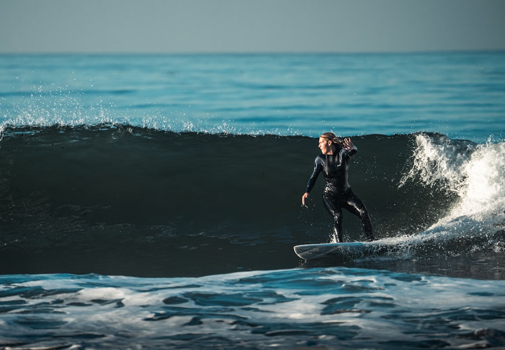 a man riding a wave on top of a surfboard