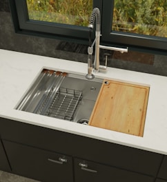 a kitchen sink with a wooden cutting board in it