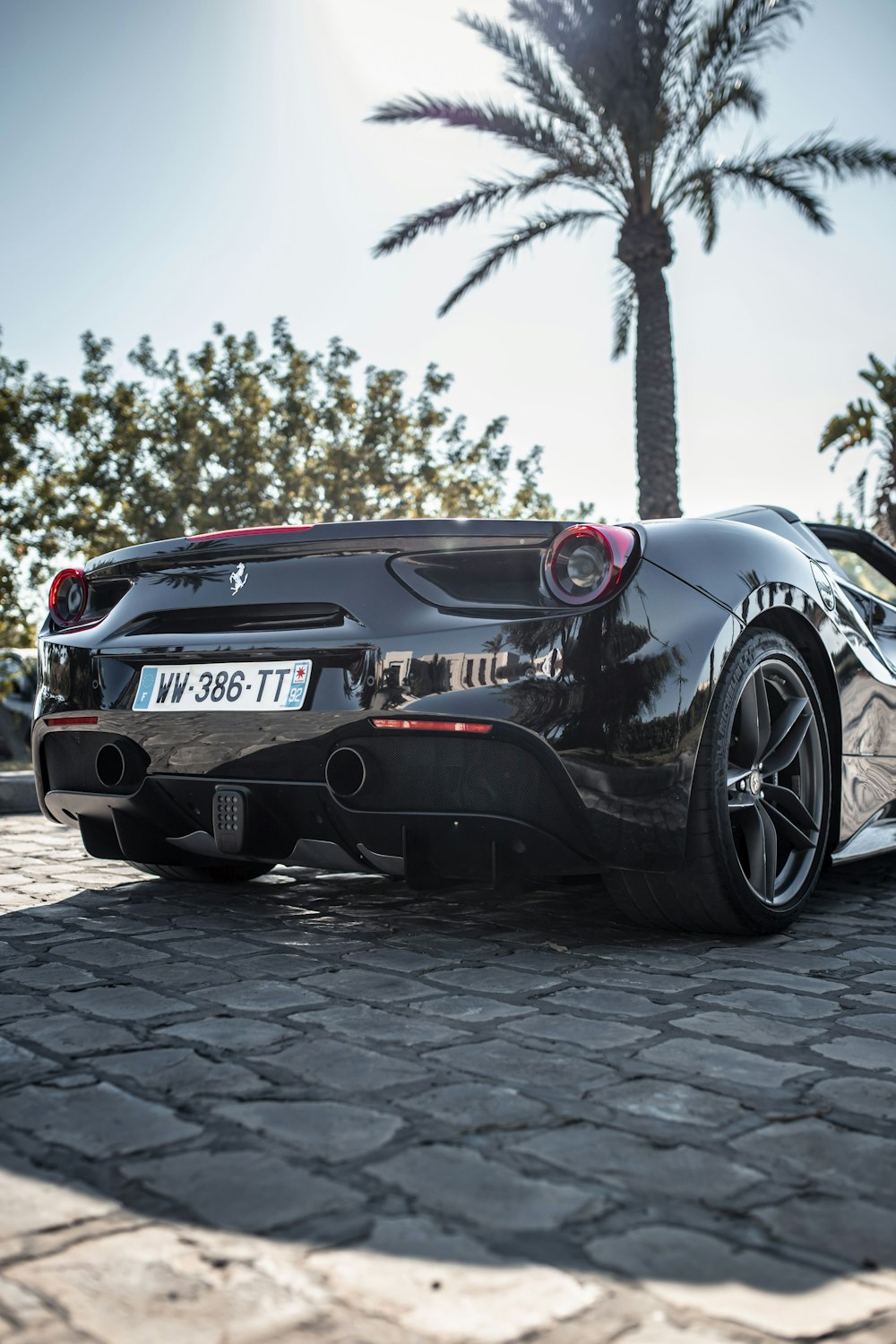 a black sports car parked on a cobblestone street