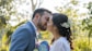 a bride and groom kissing each other outside