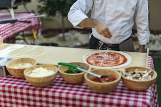a man is sprinkling cheese on a pizza