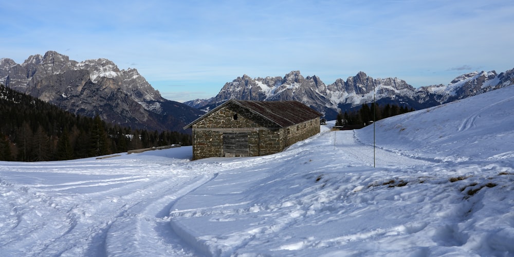 a snow covered ski slope with a building in the middle of it