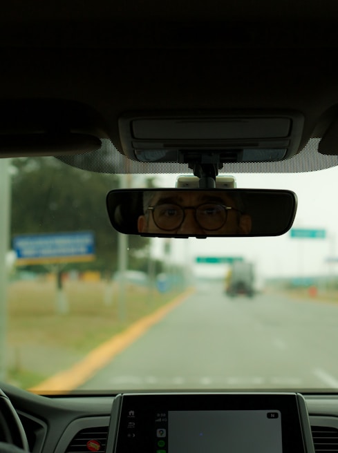 A dashboard view of a car driving on a highway with visible lane markings and road signs.
