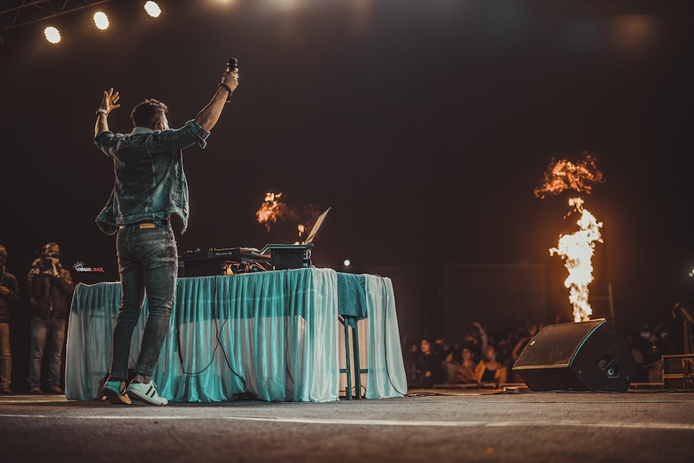 a man standing on a stage with his arms in the air