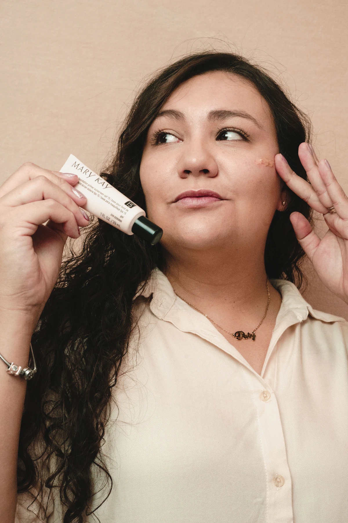 Woman holding a tube of treatment cream near her face