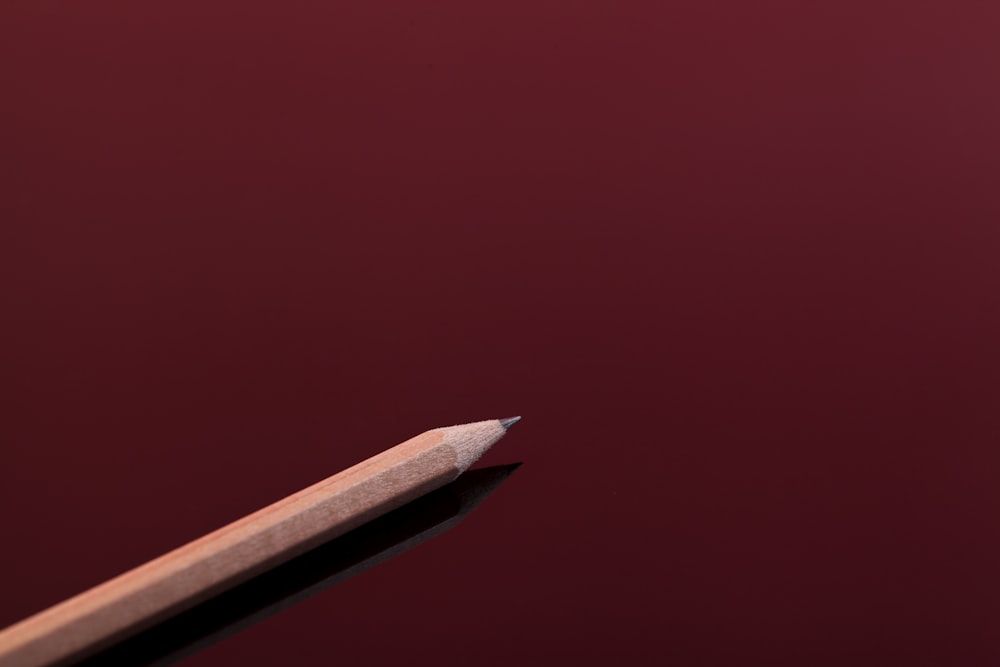 a close up of a pencil with a red background