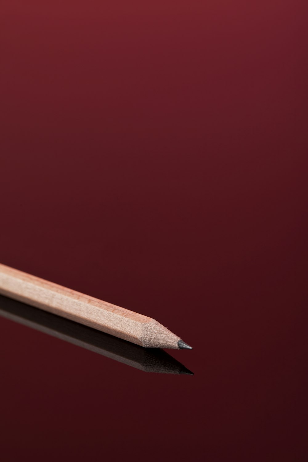 a wooden pencil resting on top of a black surface