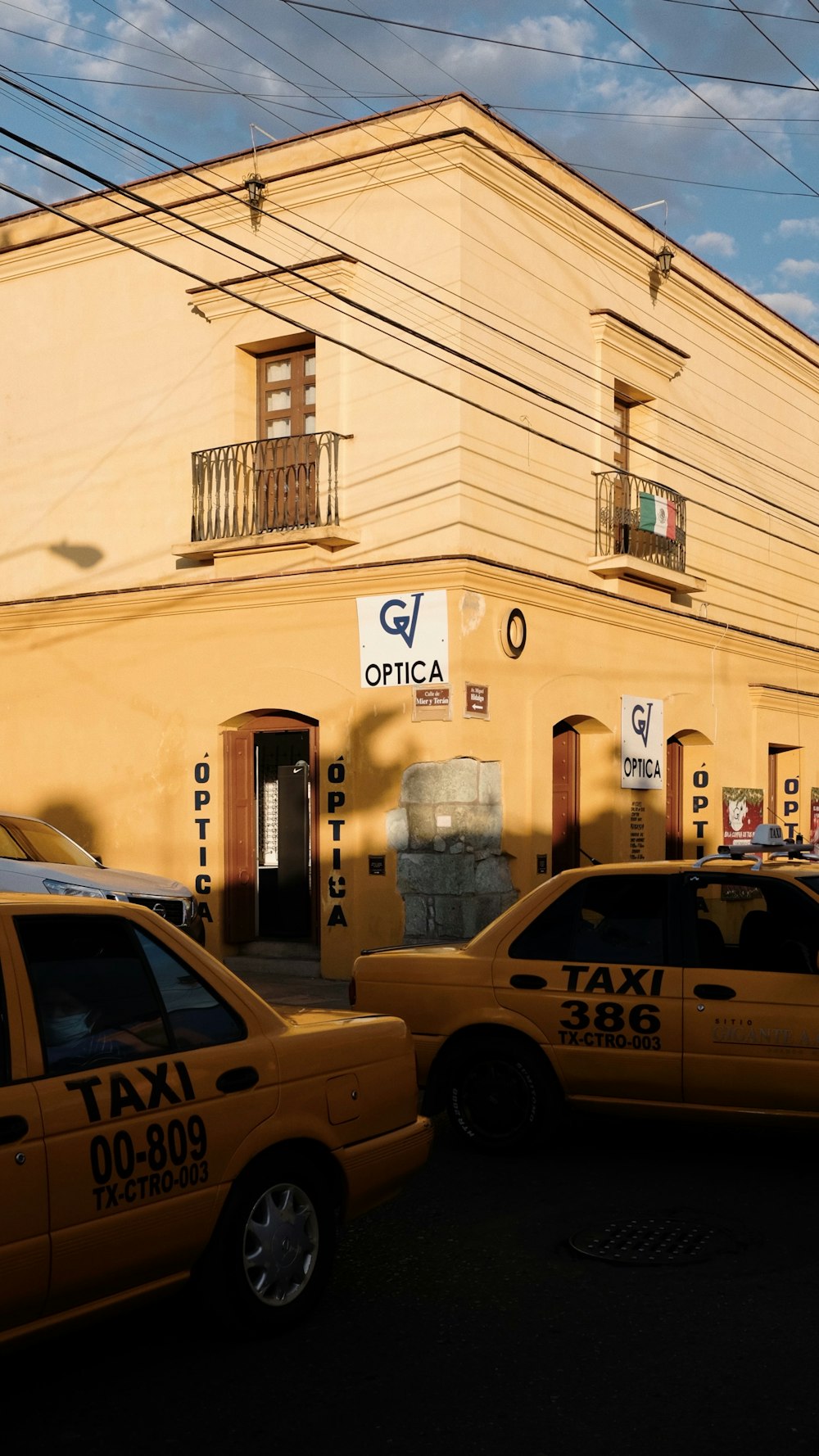 Un par de taxis estacionados frente a un edificio