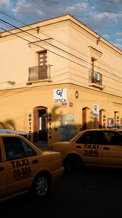 a couple of taxi cabs parked in front of a building