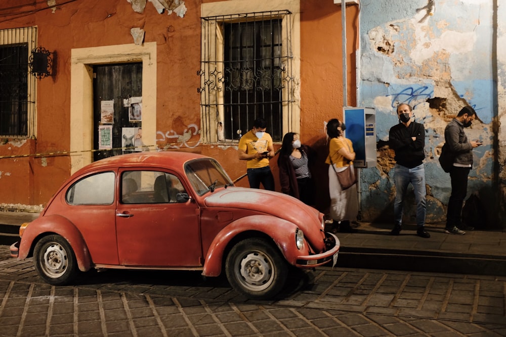 a small red car parked in front of a building