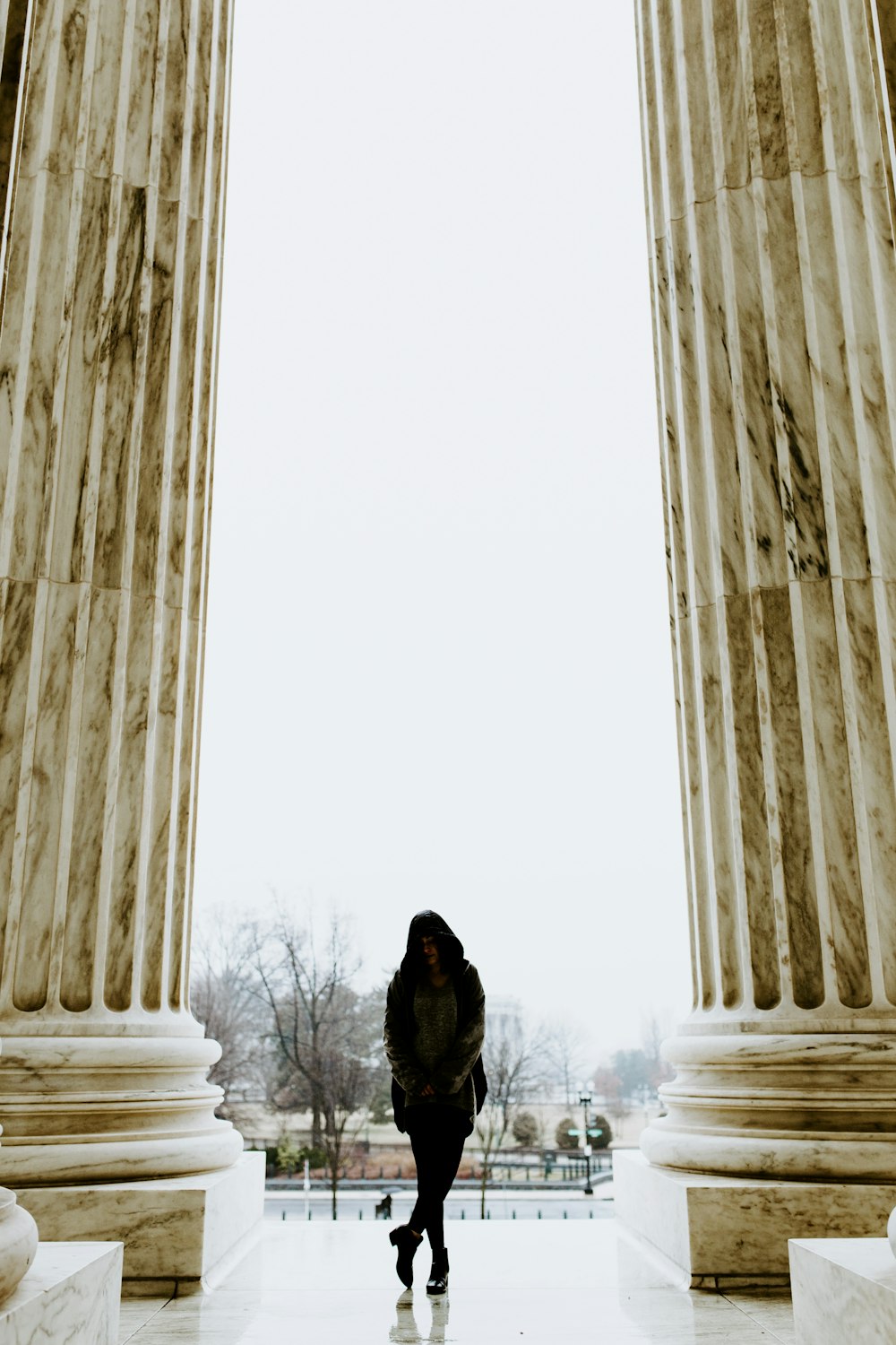 a person walking in front of two large pillars