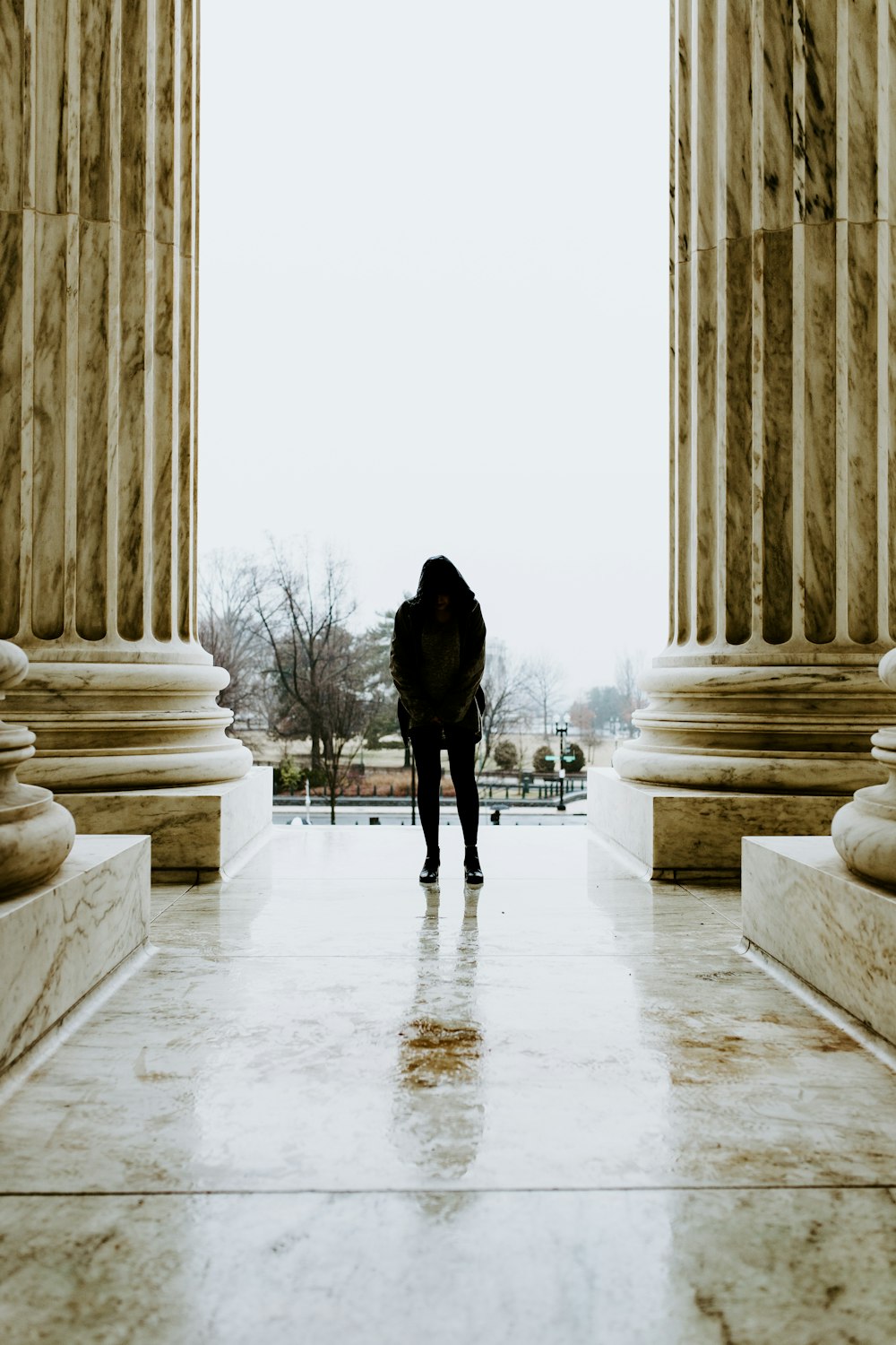 a person standing in front of some pillars