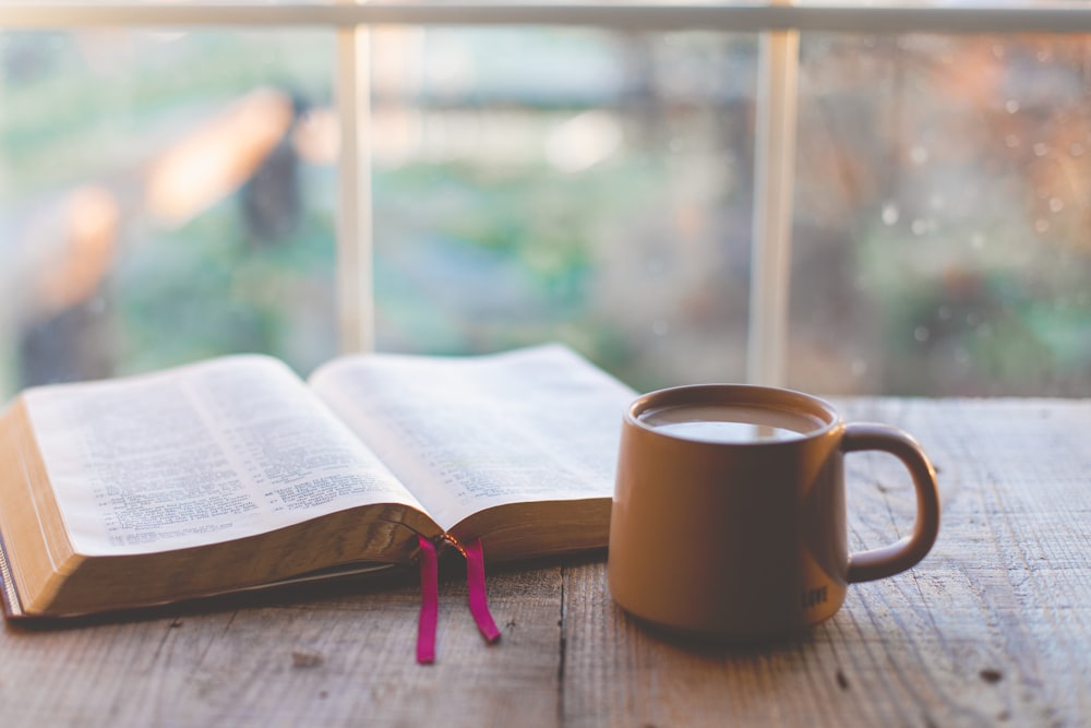 a book and a cup of coffee on a table