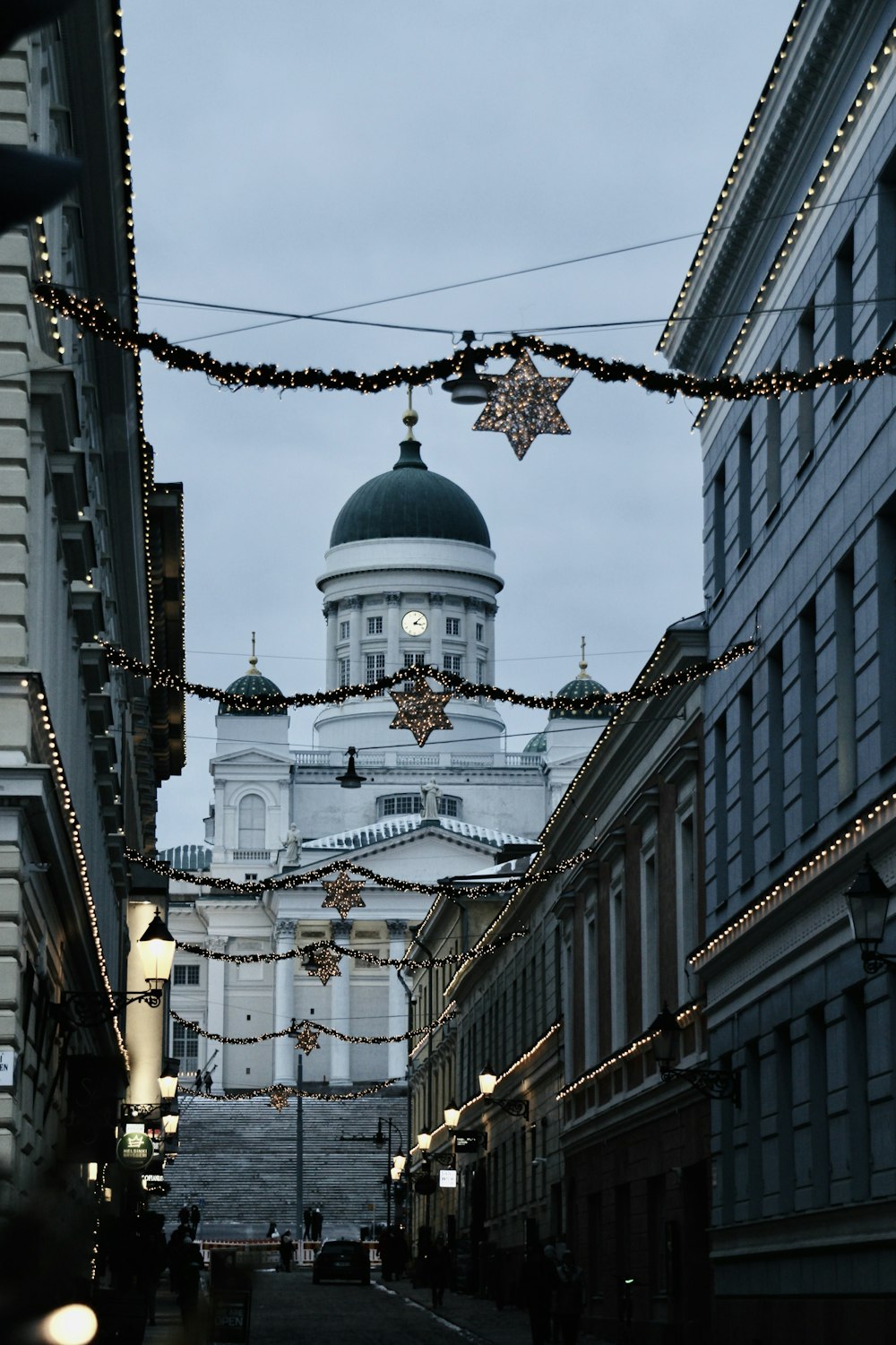 a city street with buildings and a dome in the background