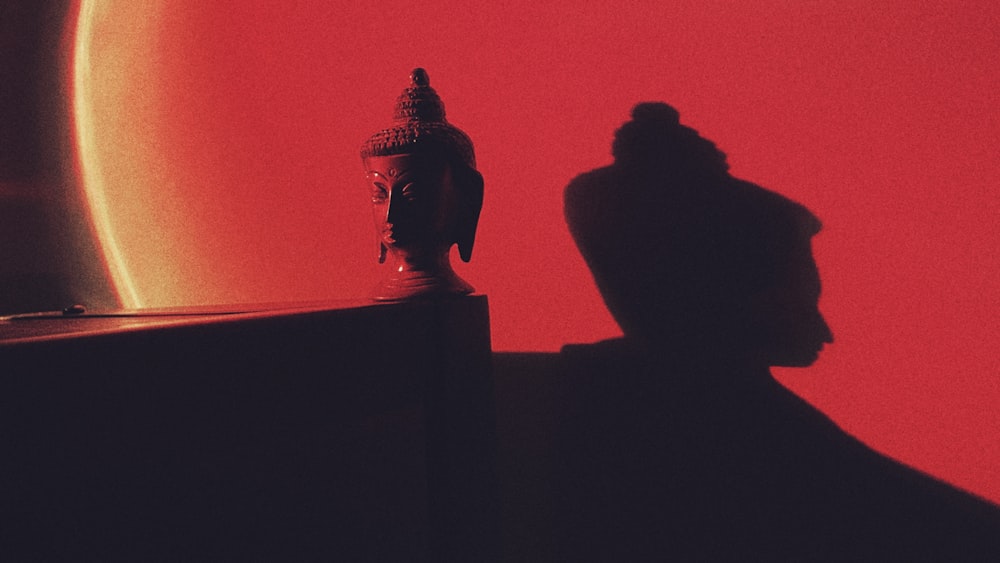 Ein Schatten einer Person, die neben einer Statue steht