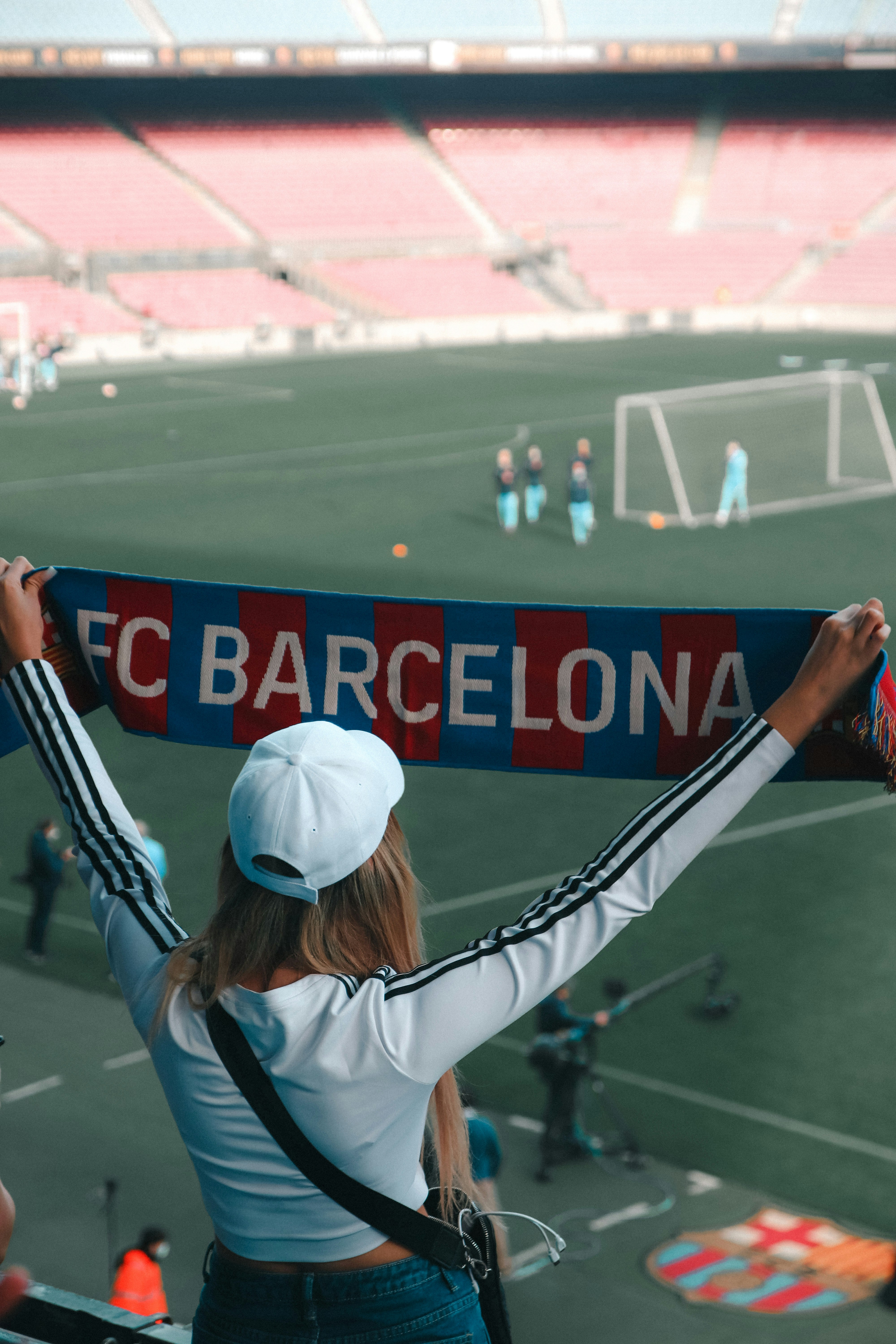 a woman holding up a scarf at a soccer game