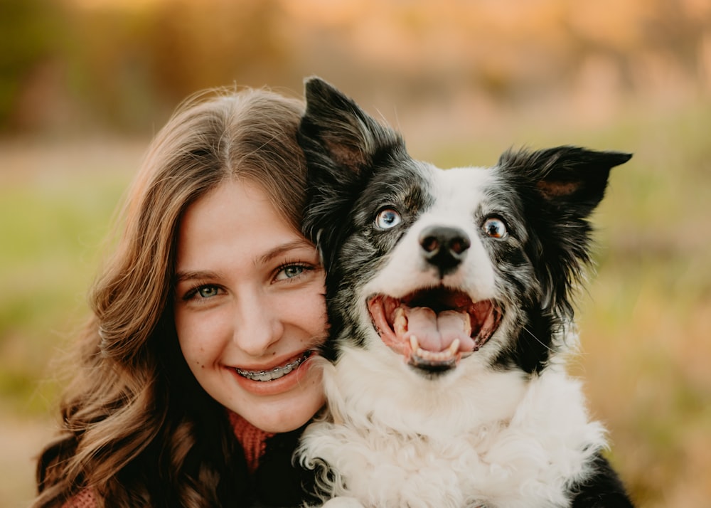 a woman is hugging a dog in a field