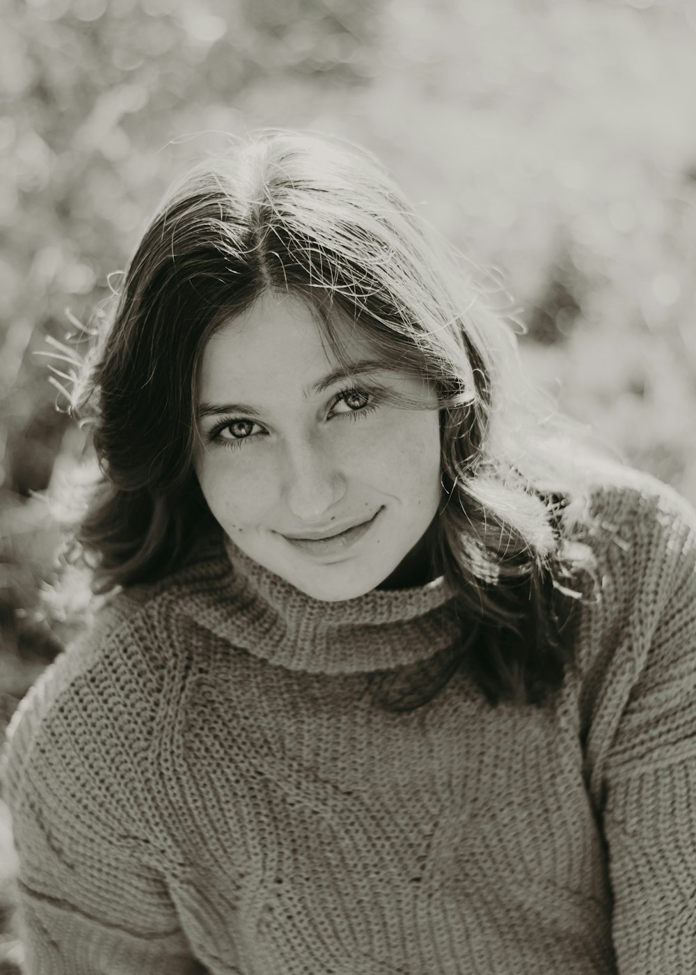 a black and white photo of a woman smiling