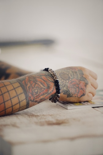 a person with a tattoo on their arm sitting on a table