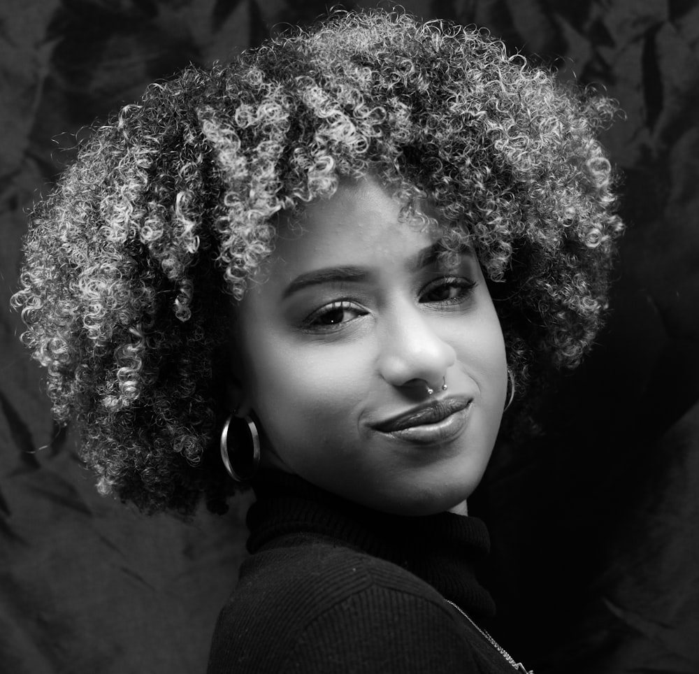 a black and white photo of a woman with curly hair