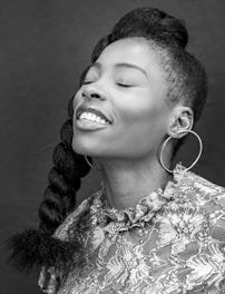 a black and white photo of a woman smiling