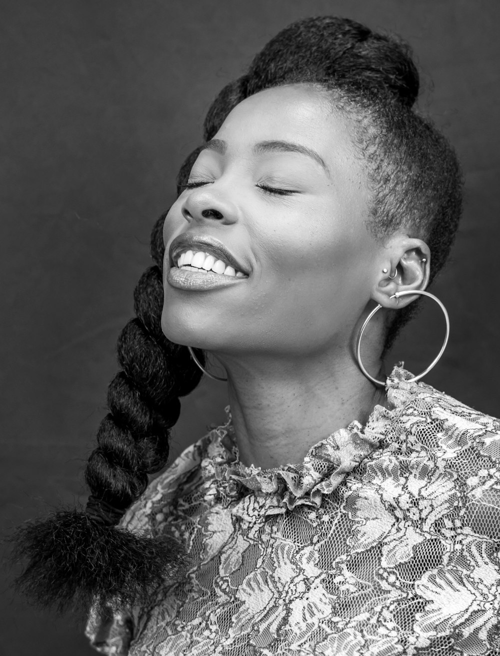 a black and white photo of a woman smiling