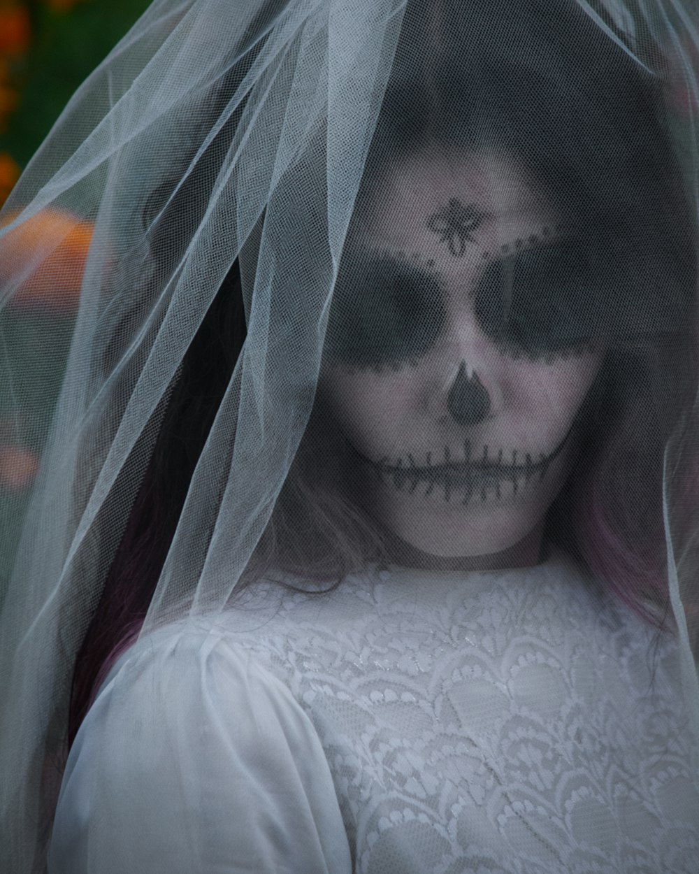 a woman wearing a veil and skull makeup