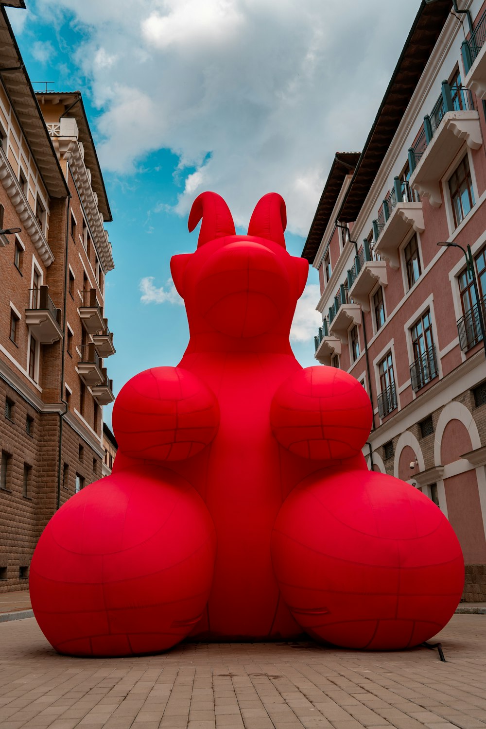 a large red sculpture sitting in the middle of a street