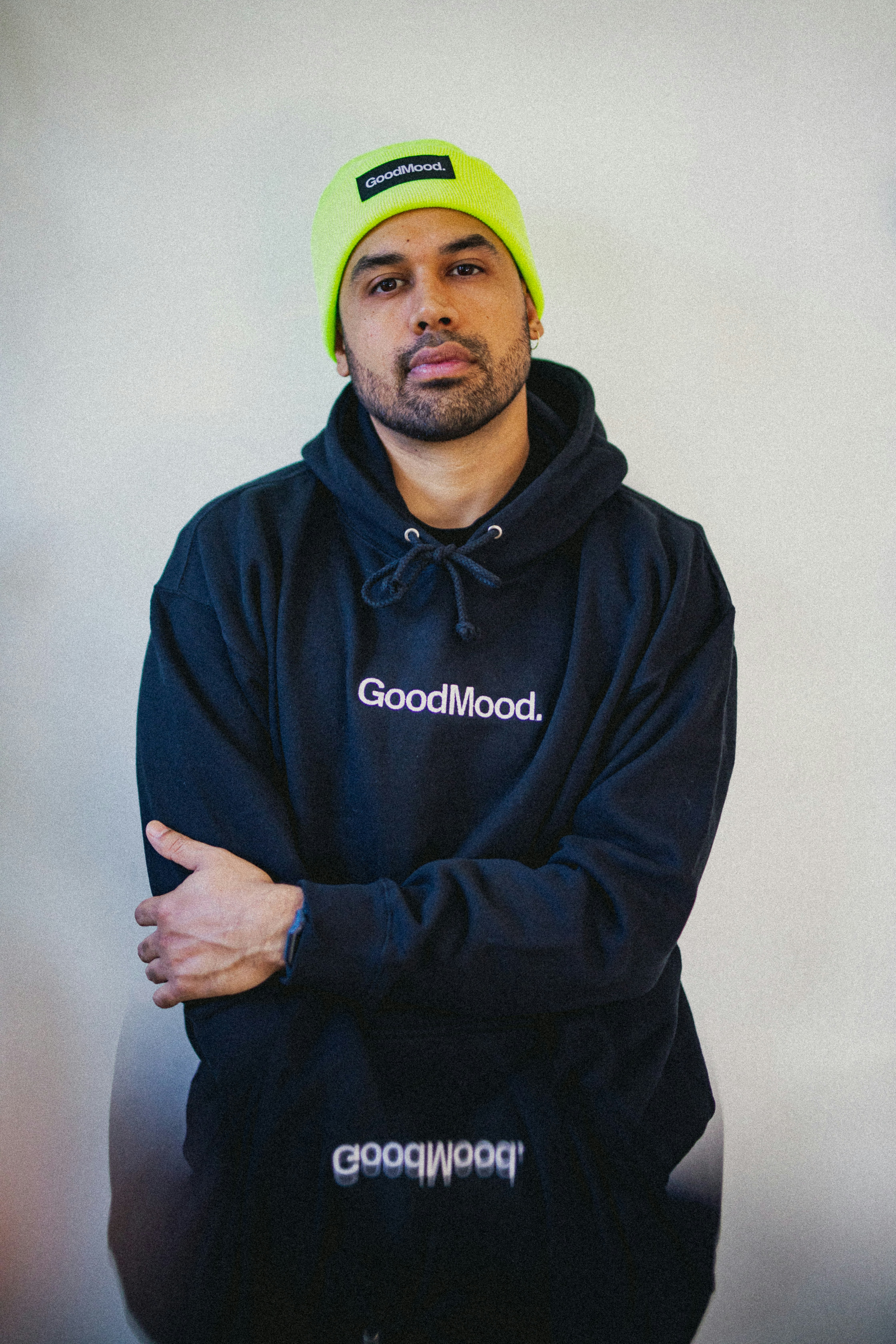 a man in a black hoodie with a yellow hat