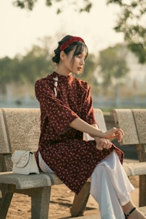 a woman sitting on top of a wooden bench