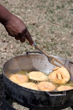 a person is frying donuts in a pan