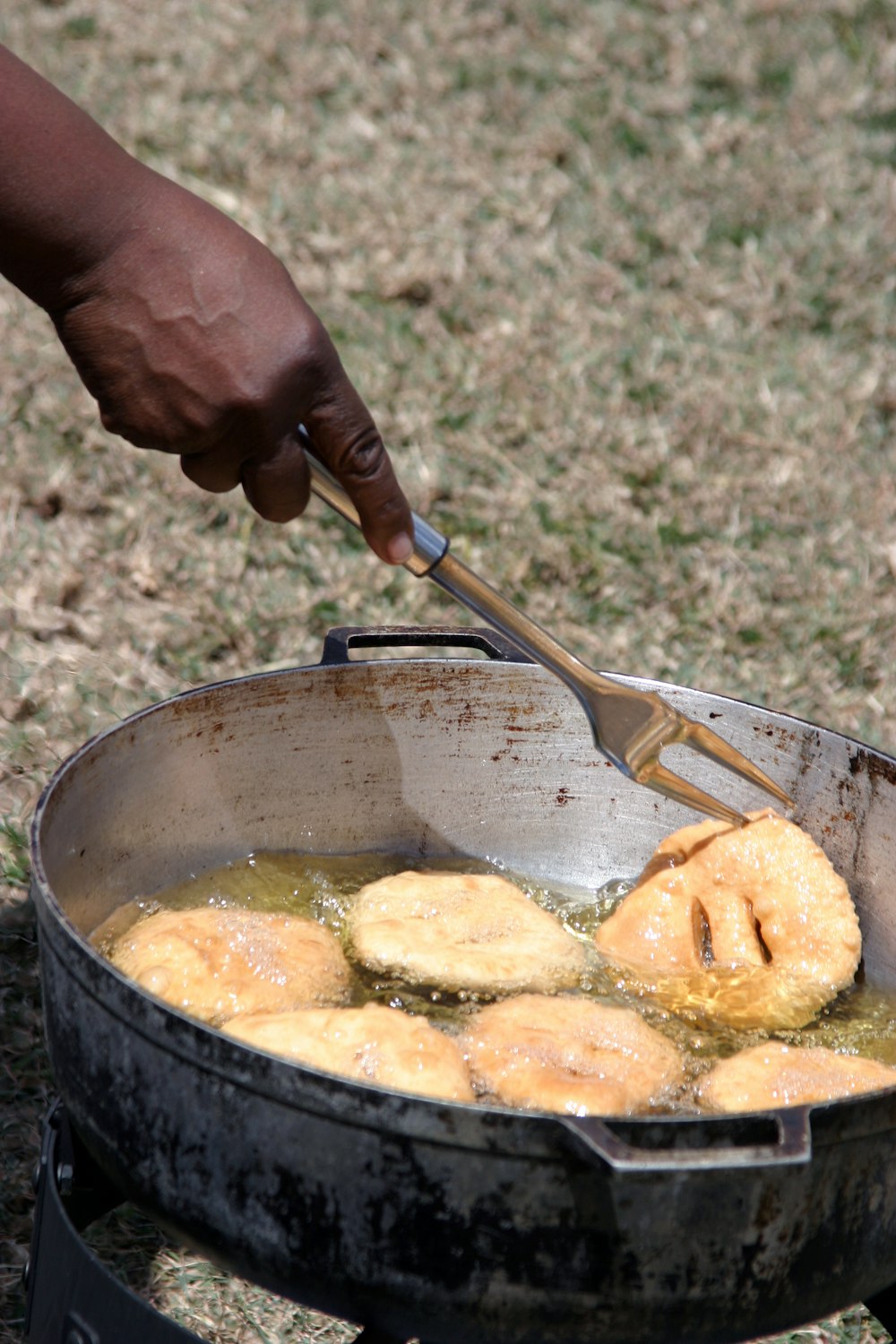 a person is frying donuts in a pan