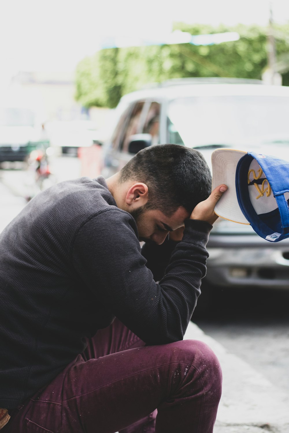 a man sitting on the ground with his head in his hands