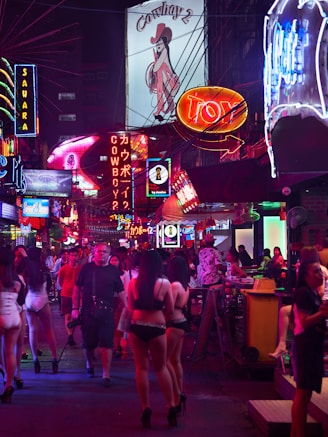 a group of people walking on a city street at night