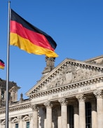 a german flag flying in front of a building