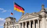 a german flag flying in front of a building