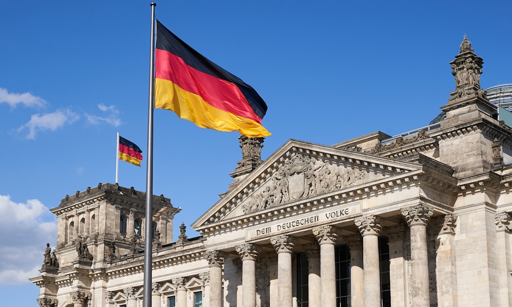 Una bandera alemana ondeando frente a un edificio
