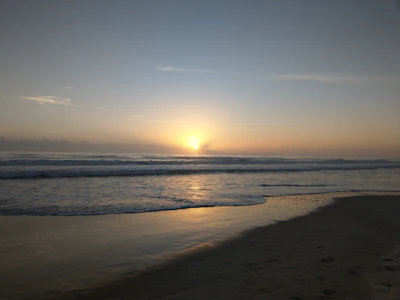 Sunrise over Puri sea beach with soft golden light reflecting on gentle waves.