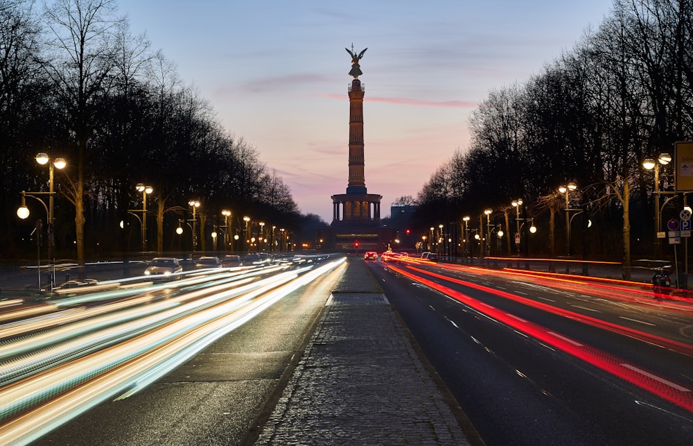 a long exposure shot of a street with a monument in the background