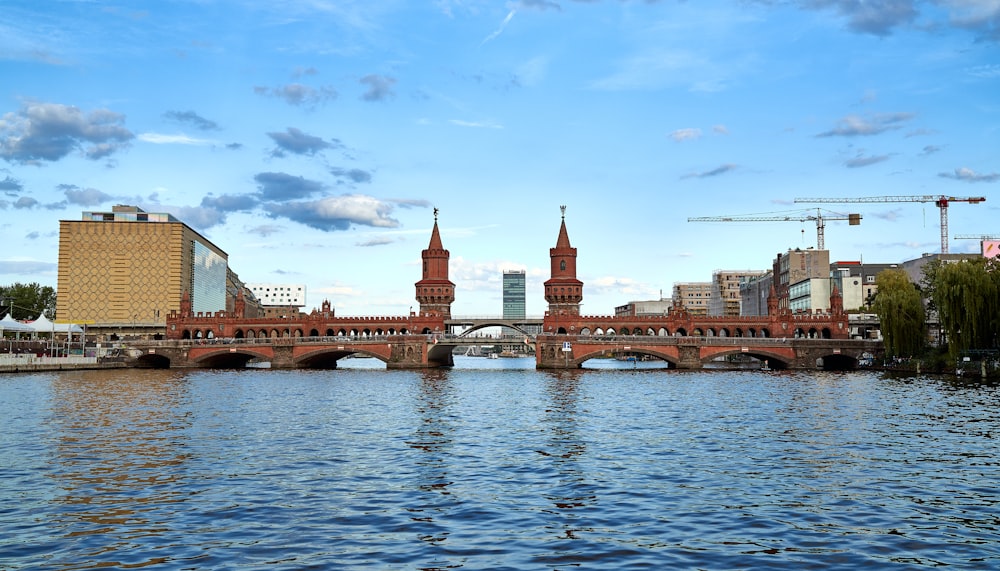 a bridge over a body of water with tall buildings in the background