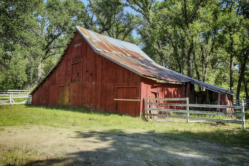 a red barn with a metal roof in a field