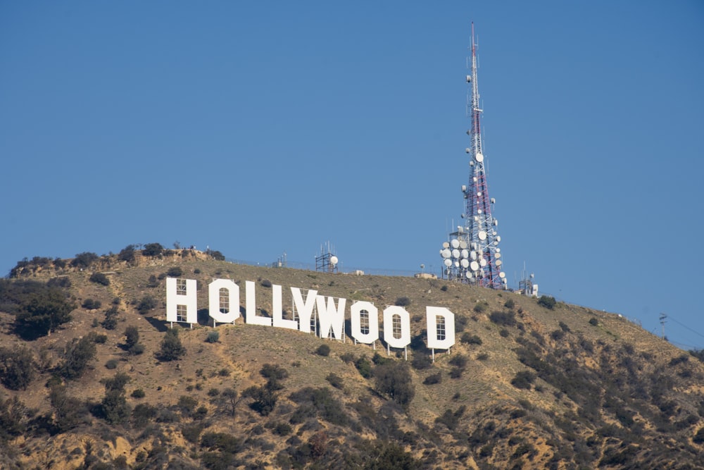a hollywood sign on a hill with a radio tower in the background