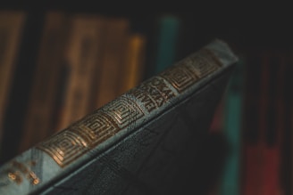 A close-up of a book spine showing the Editora Impactante logo in gold on a black background.