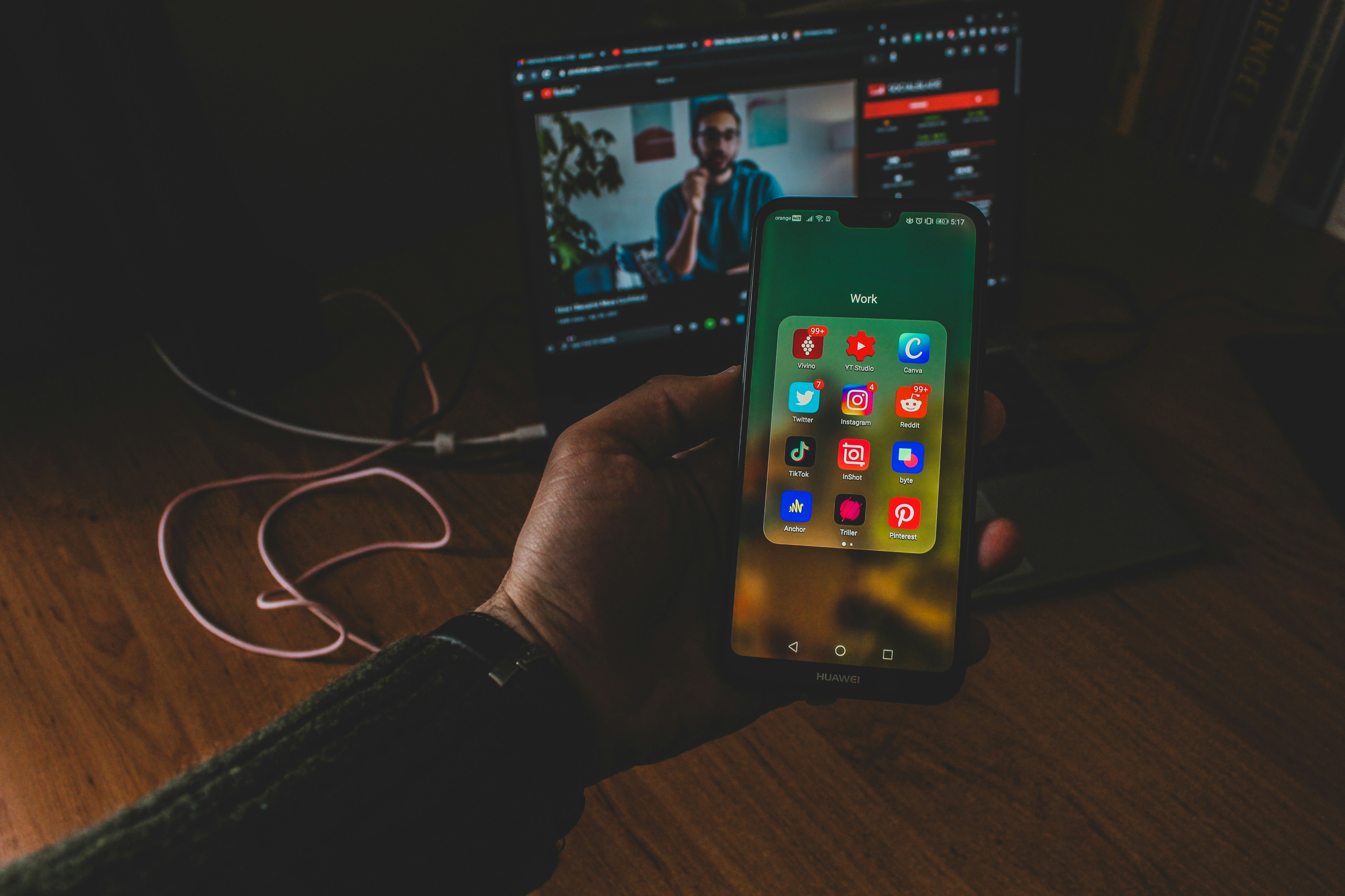 a person holding a cell phone in front of a laptop