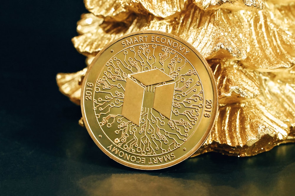 a gold coin sitting on top of a pile of gold foil