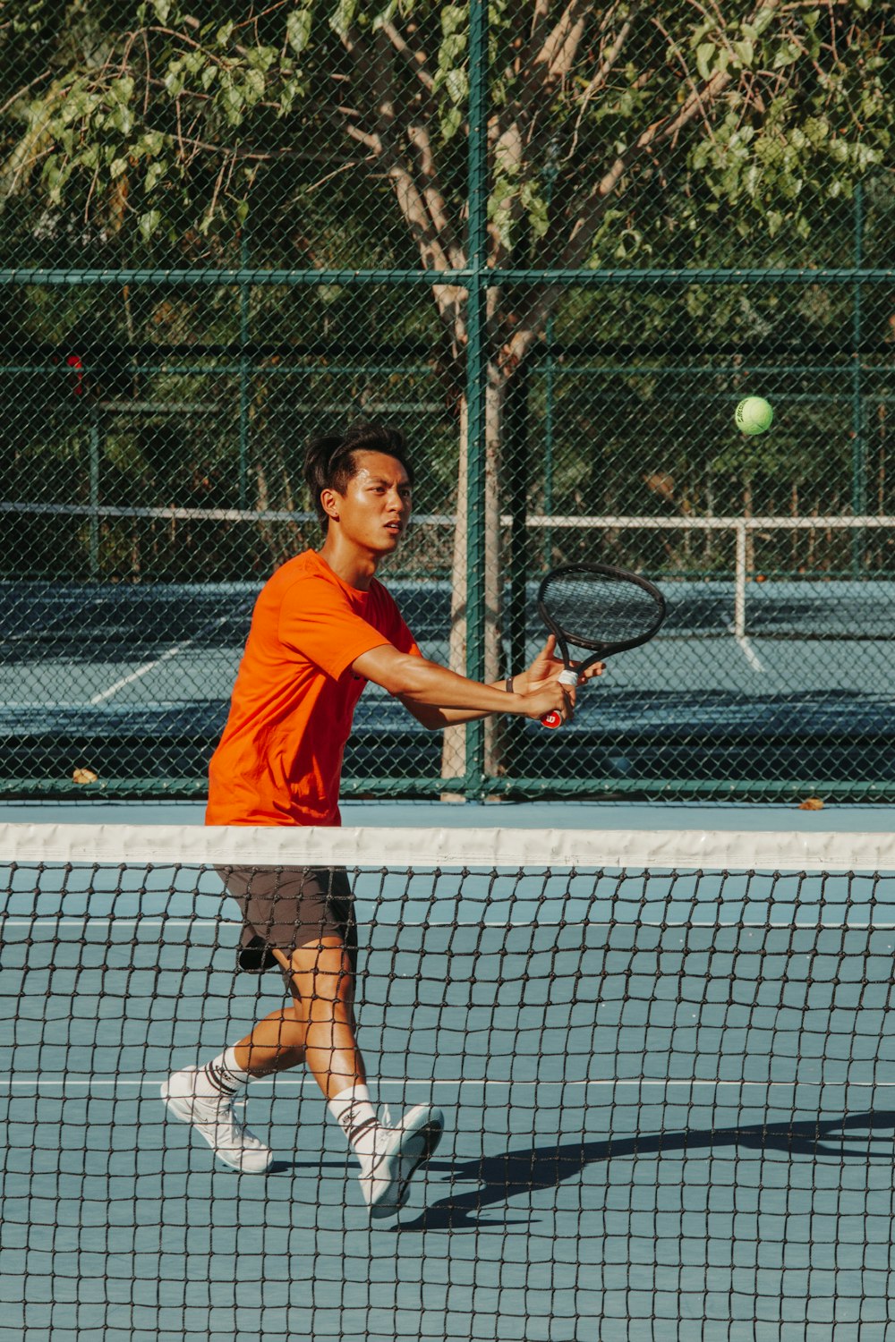 a man is swinging a tennis racket at a ball