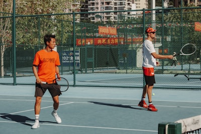 a couple of men standing on a tennis court holding racquets